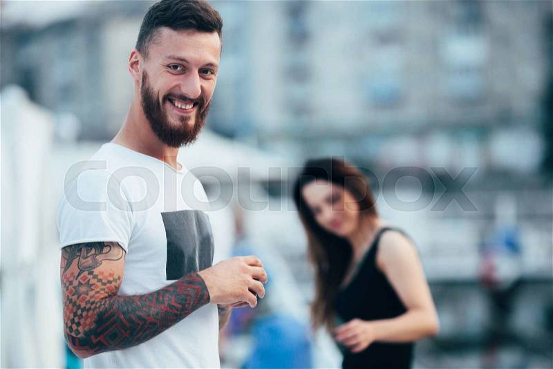 Couple posing against the backdrop of the city by the lake, stock photo