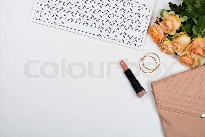 Feminine office desk workspace mockup with flowers, handbag, beige lipstick, keyboard and notepad on white background, stock photo