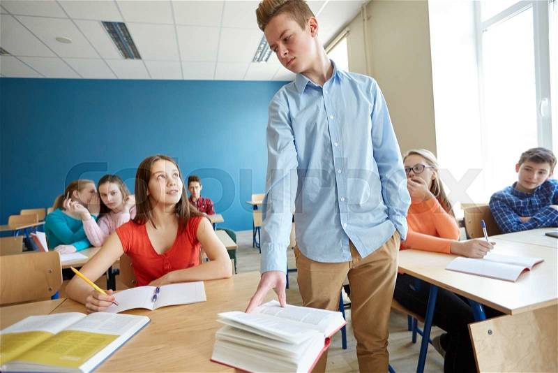 Education, bullying, conflict, social relations and people concept - student boy behaving unfriendly to girl at school, stock photo