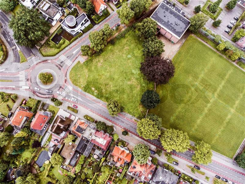 Aerial view of Dutch town, private houses, streets and roundabout, green park with trees, stock photo