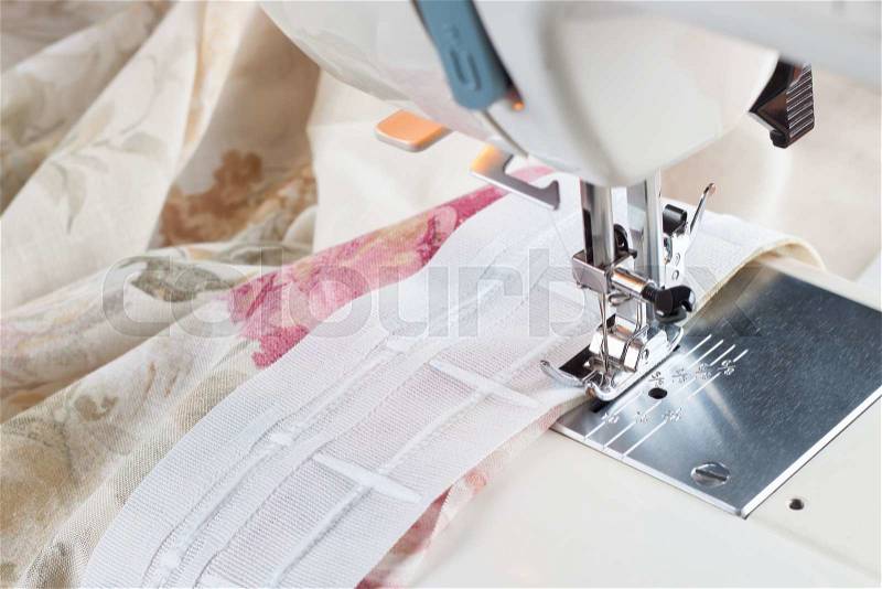 Sewing process by a curtain tape on the sewing machine, stock photo
