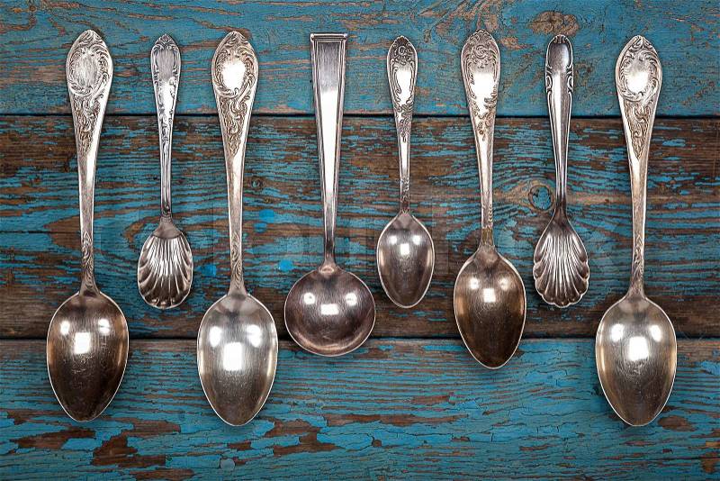 German silver spoon and fork on a wooden background. Kitchen utensils, stock photo