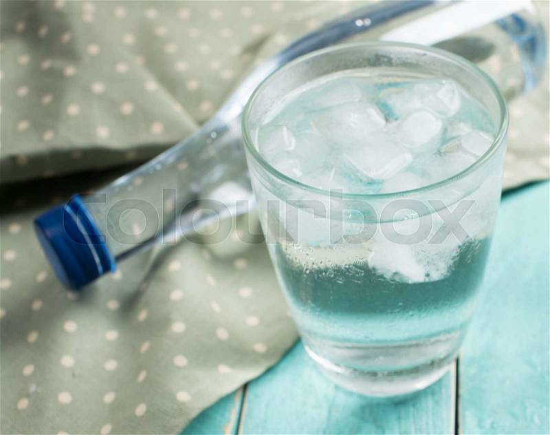 Glasses of water with ice on blue wood background, stock photo