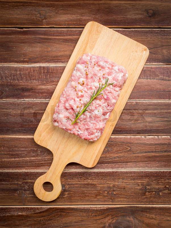 Minced pork uncooked with cutting board on wood background, top view, stock photo