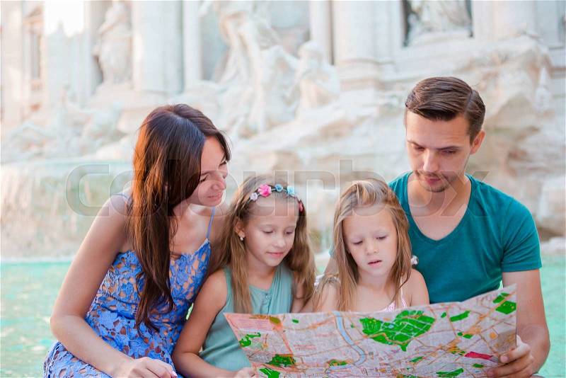 Family with touristic map near Fontana di Trevi, Rome, Italy. Happy father and kids enjoy italian vacation holiday in Europe, stock photo