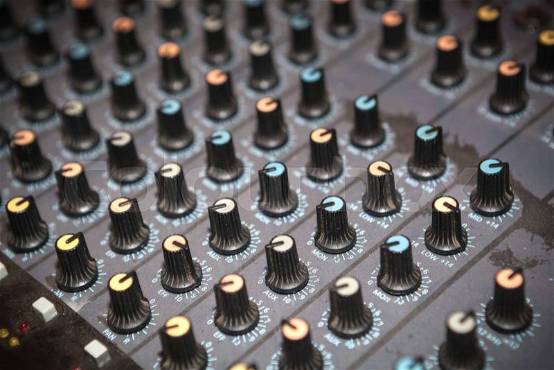 Dusty audio studio mixer knobs panel. Shallow depth of field, stock photo