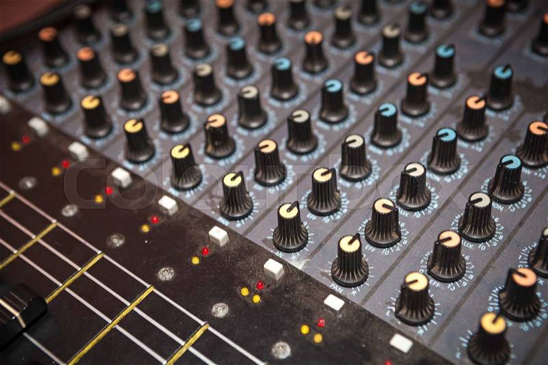 Dusty audio studio mixer knobs panel. Selective focus, stock photo