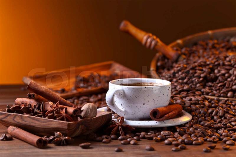 Cup of black coffee and roasted beans with spices, stock photo