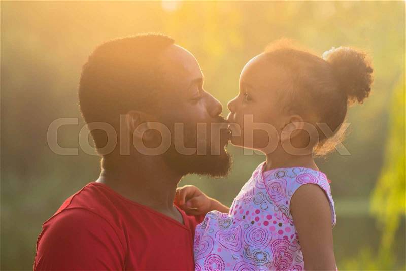 African father hugging and kissing a baby daughter. Happy fatherhood concept, stock photo