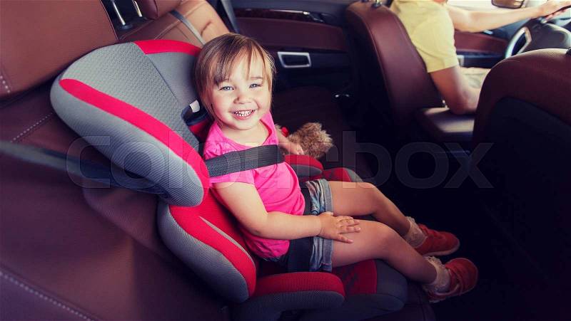 Family, transport, safety, road trip and people concept - happy little girl sitting in baby car seat and father driving, stock photo