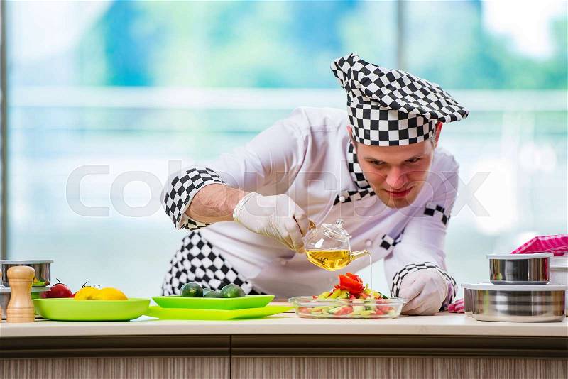 The male cook preparing food in the kitchen, stock photo