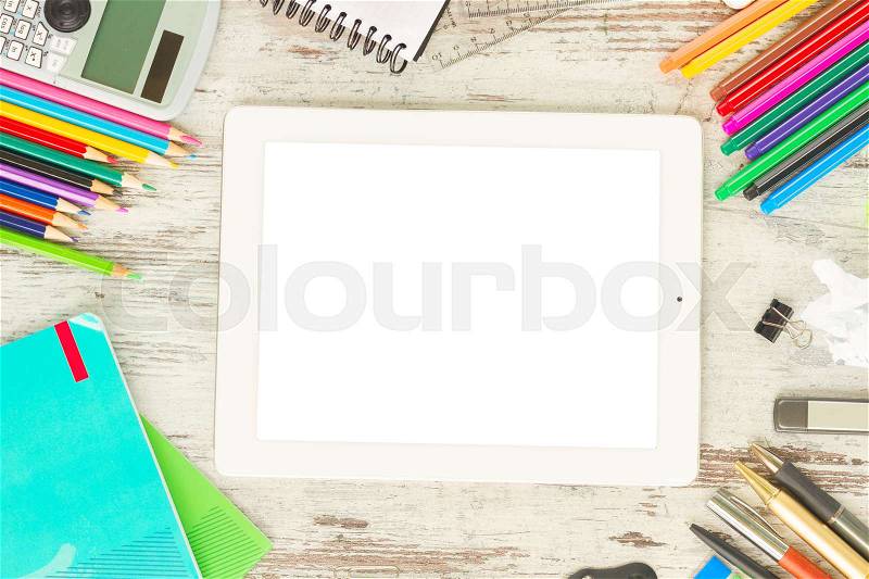Back to school frame with school supplies and tablet with empty screen on wooden table, stock photo