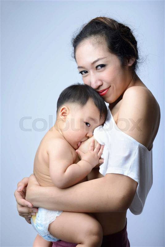 Young asian mother holding her baby and breast feeding baby, stock photo