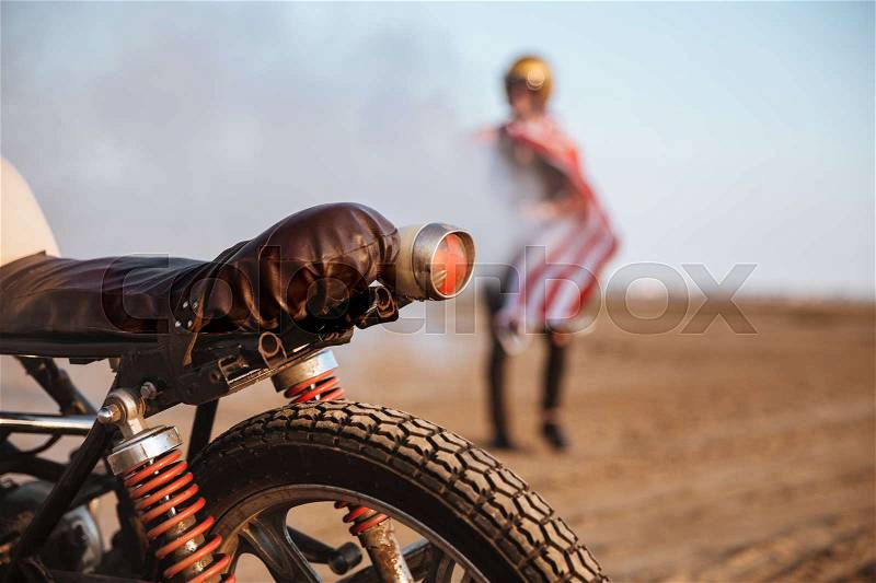 Close up of motorcycle wheel and flashlights with a man on the backgroud, stock photo