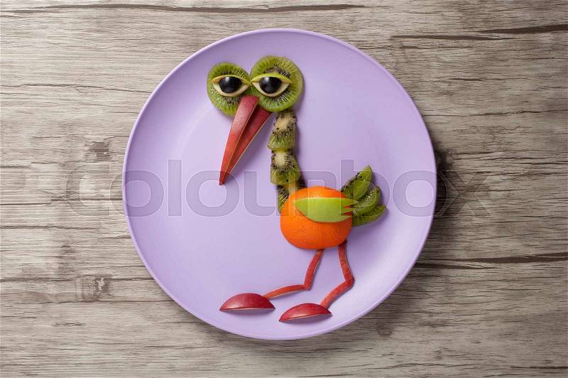 Heron made of fruits on plate and desk, stock photo