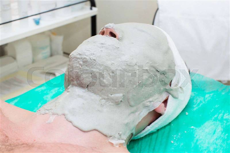 Man in the mask cosmetic procedure in spa salon, stock photo