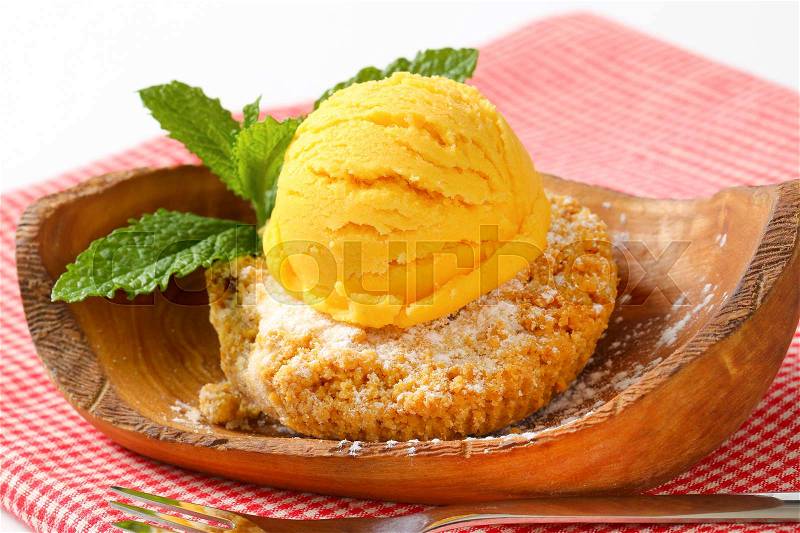 Almond cookie and scoop of ice cream served on olive wood bowl, stock photo