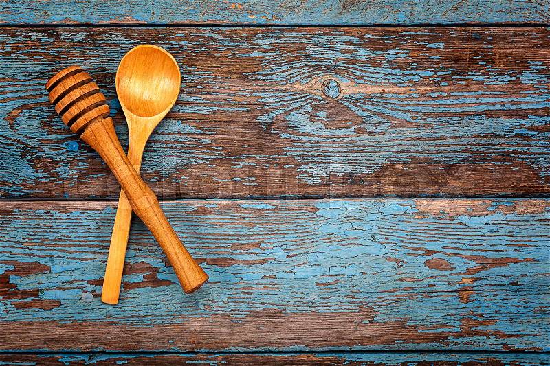 Spoon and stick to honey. Set kitchen utensils on a wooden background. Accessories for cooking, stock photo
