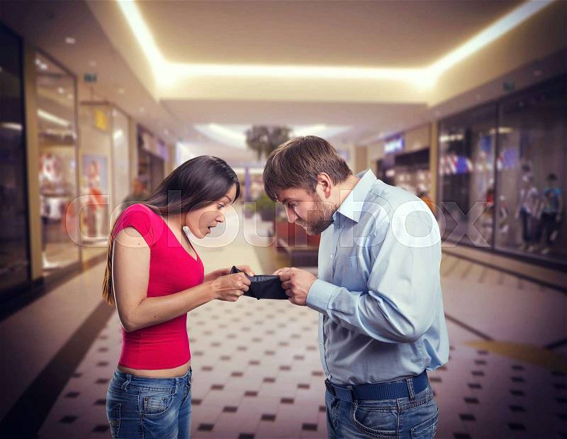 Woman and man looking for money in an empty purse, stock photo