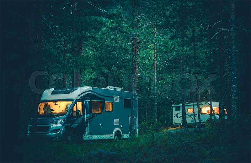 Motorhomes Camping in a Wild. RV Boondocking in the Forest at Night. Traveling in the Camper Van, stock photo