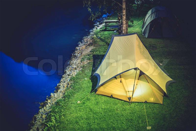Tent Camping at Night. Two Large Tents on the Campsite. Waterfront Campground, stock photo