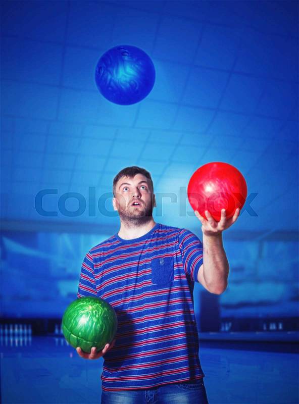 Man juggling with bowling balls, stock photo