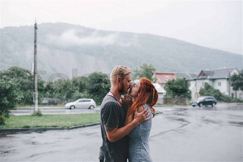 Beautiful couple hugging on outside in the rain, stock photo
