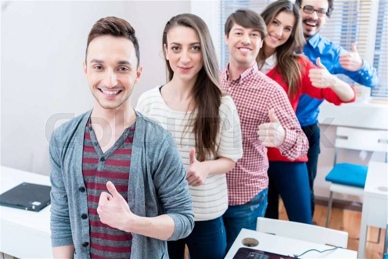 Students in college being successful showing thumbs up having fun, stock photo