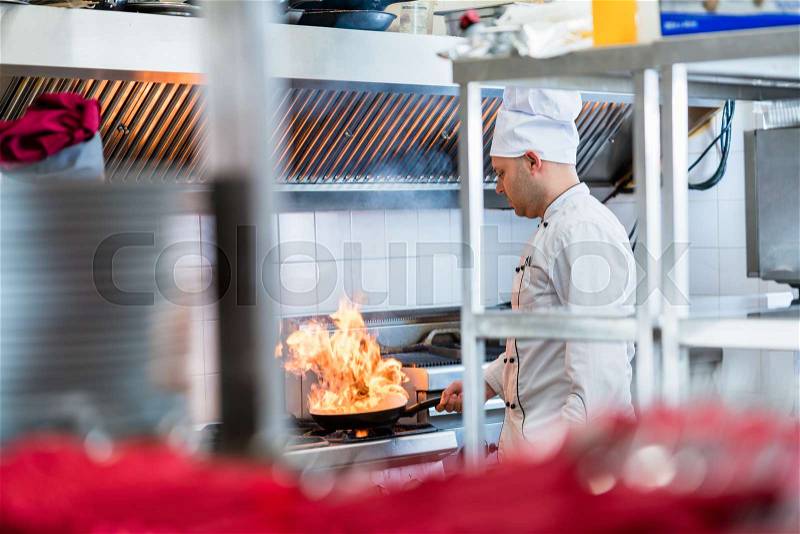 Chef or cook in hotel kitchen cooking dishes, stock photo