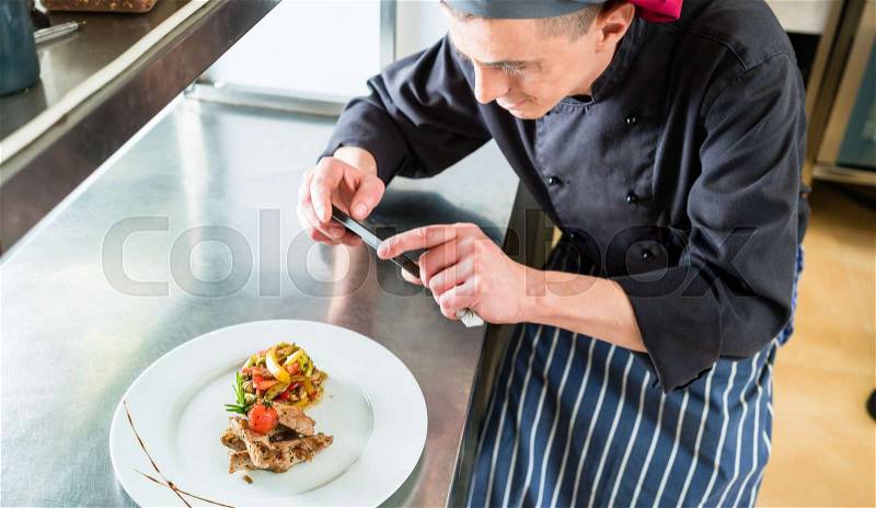 Chef making picture of food he cooked with phone, stock photo