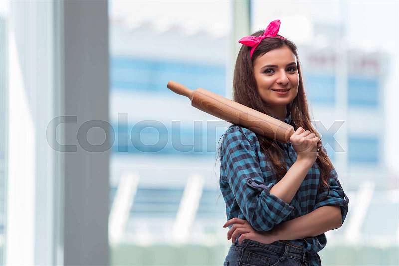 Woman with rolling pin in the kitchen, stock photo