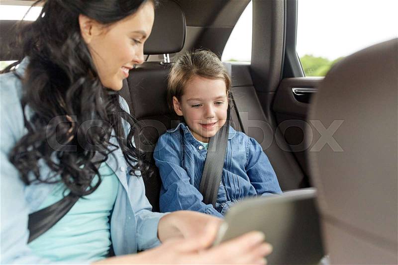 Family, transport, road trip, travel and people concept - happy woman and little daughter with tablet pc computer driving in car, stock photo
