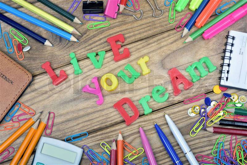 Live your dream text and office tools on wooden table, stock photo
