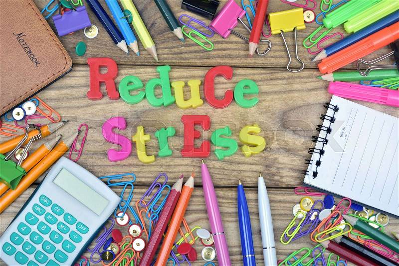 Reduce Stress text and office tools on wooden table, stock photo