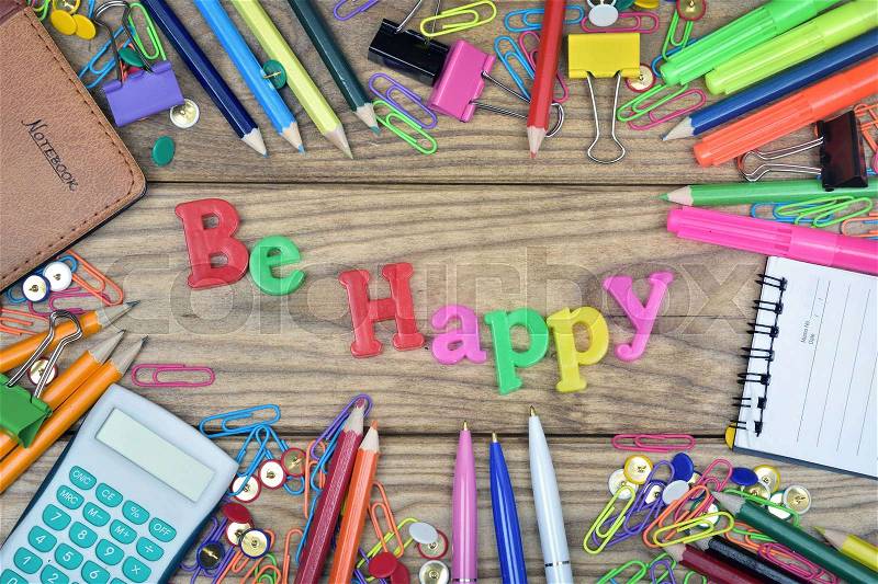 Be Happy word and office tools on wooden table, stock photo