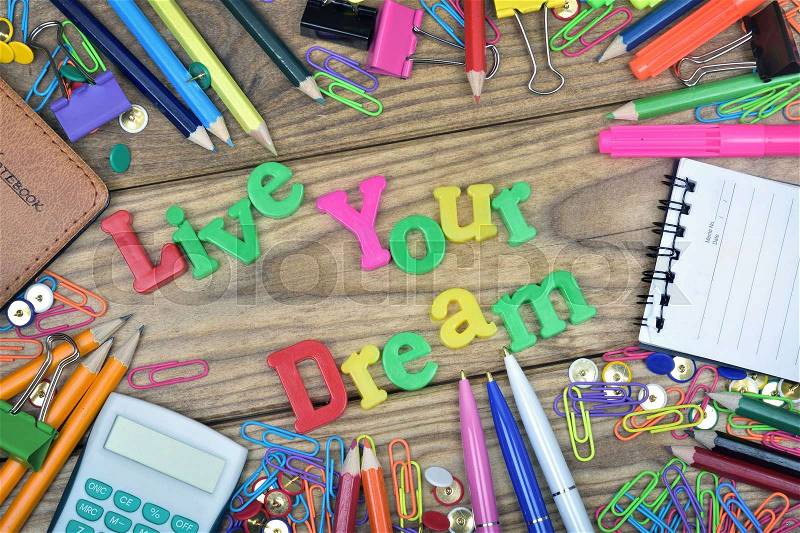 Live your dream text and office tools on wooden table, stock photo