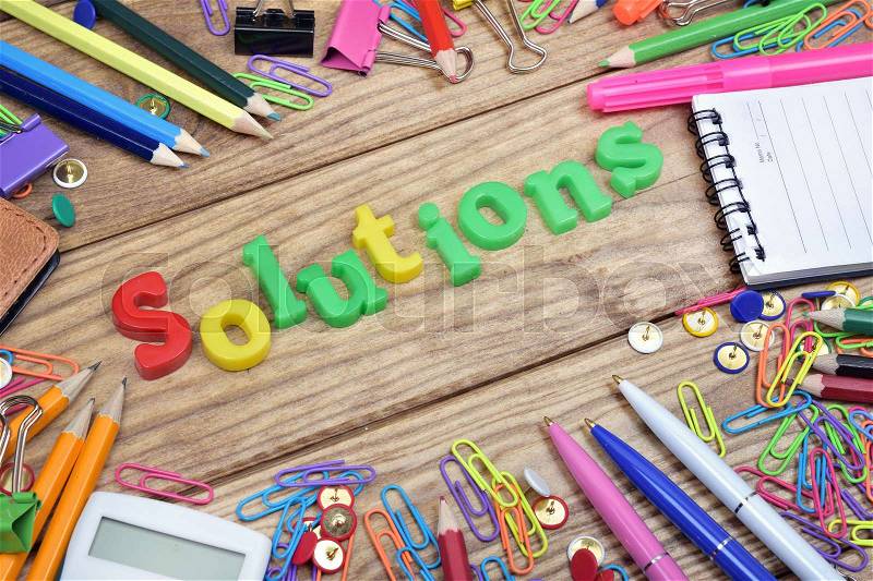 Solutions word and office tools on wooden table, stock photo