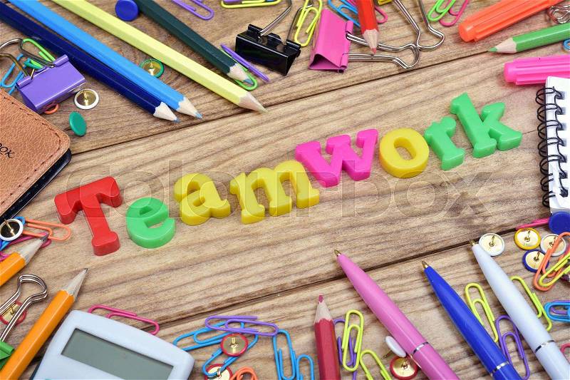 Teamwork word and office tools on wooden table, stock photo