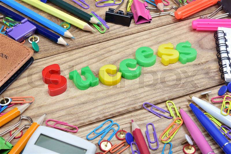 Success word and office tools on wooden table, stock photo