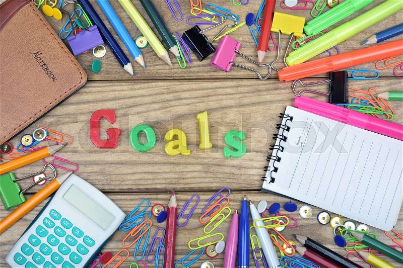 Goals word and office tools on wooden table, stock photo