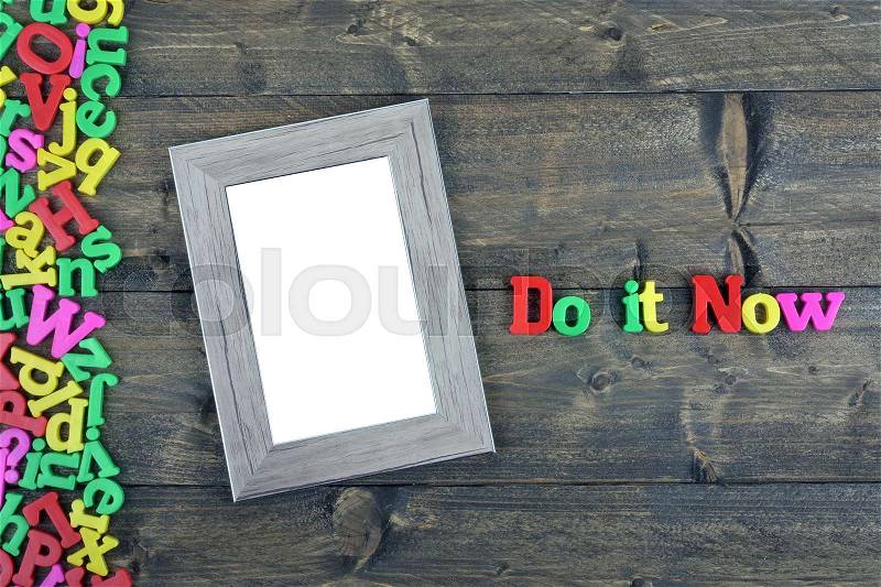 Do it now word on wooden table, stock photo