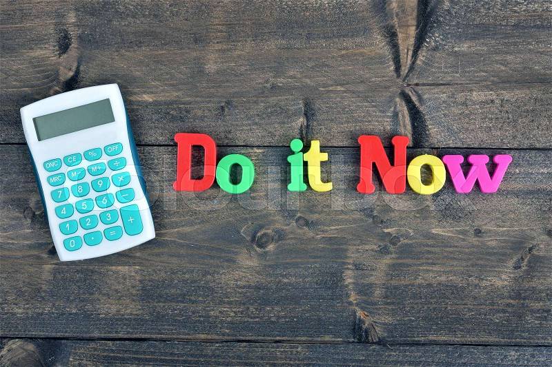 Do it now word on wooden table, stock photo