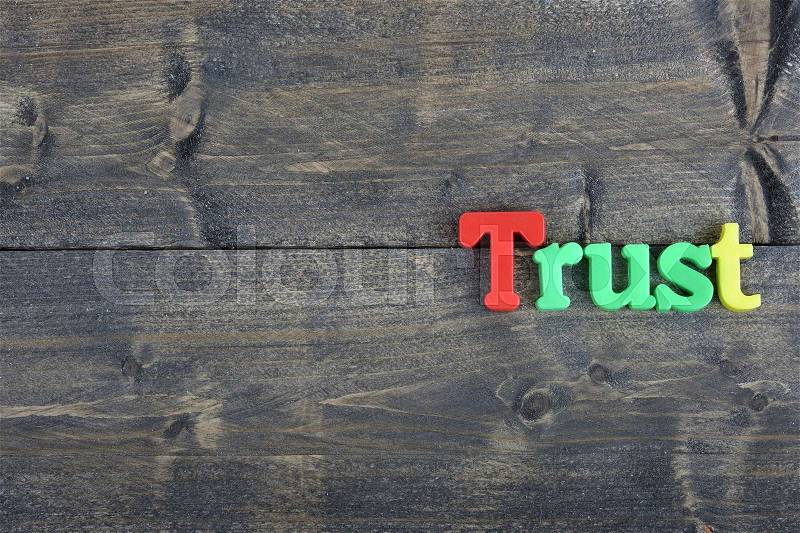 Trust word on wooden table, stock photo