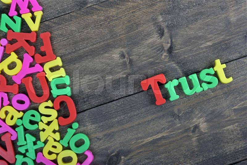 Trust word on wooden table, stock photo
