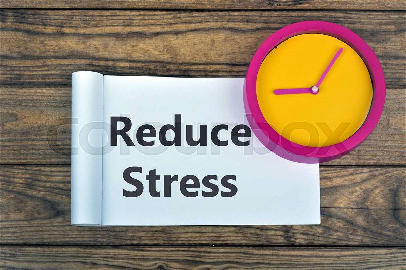Clock and word Reduce Stress on wooden table, stock photo