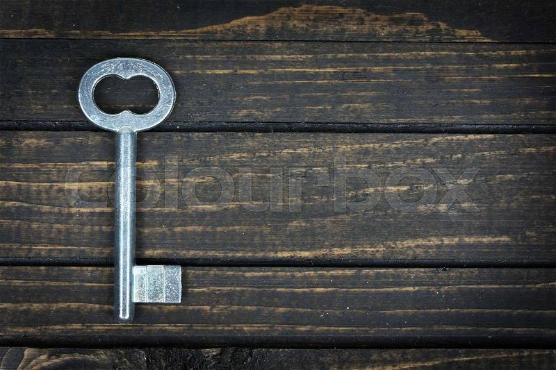 Old key on wooden table, stock photo