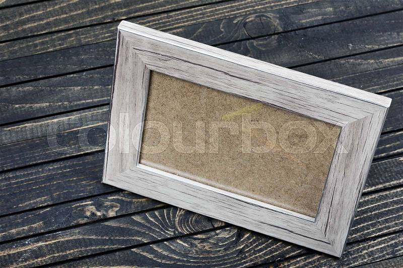 Photo frame on wooden table, stock photo