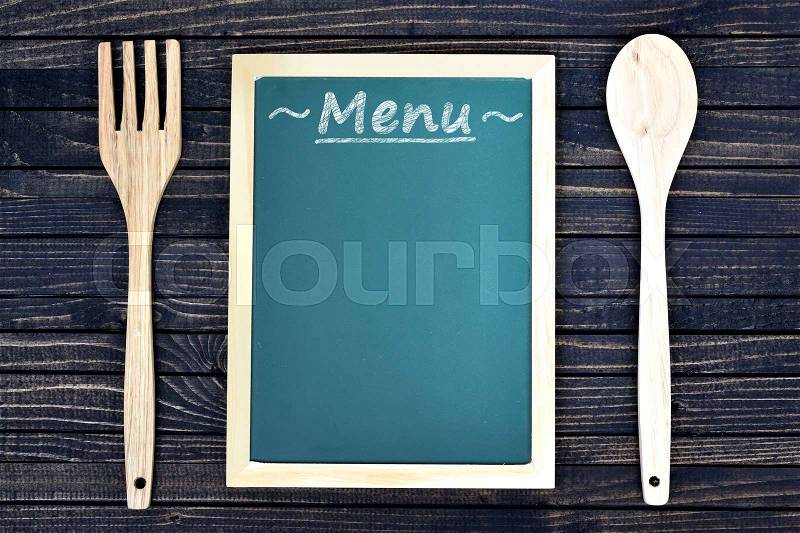 Kitchen utensils and menu on wooden table, stock photo