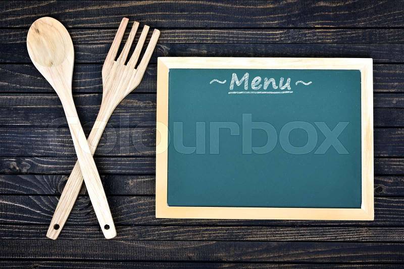 Kitchen utensils and menu on wooden table, stock photo
