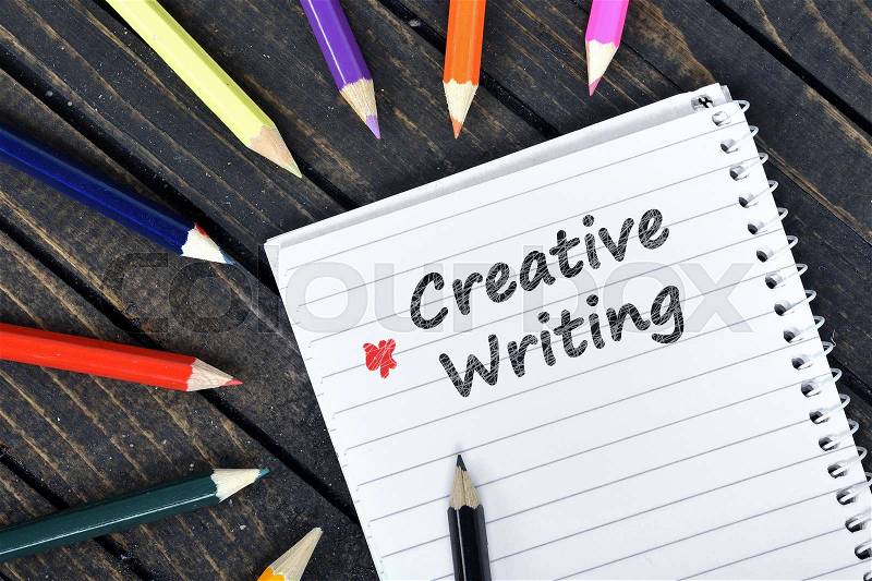 Creative Writing text on notepad and colorful pencils, stock photo